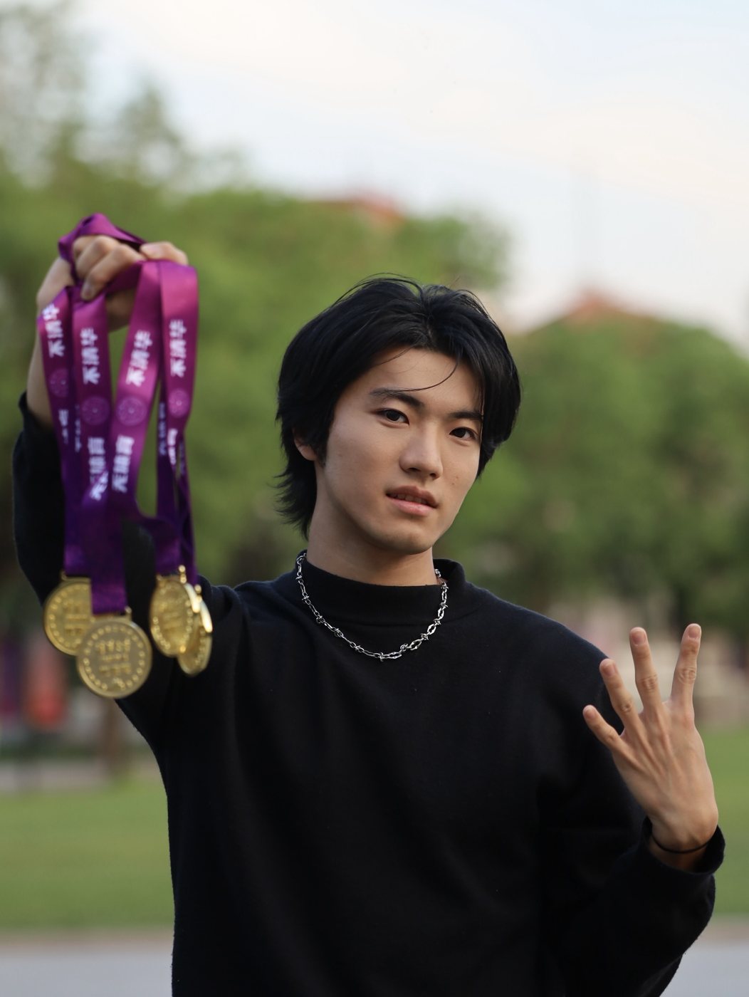 手举四枚马约翰杯金牌，比出四的手势